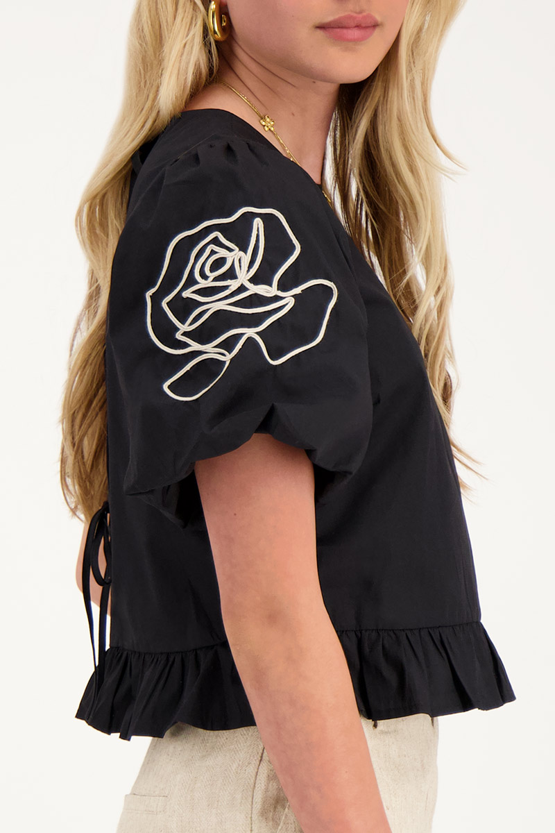 Black blouse with floral detail and bows at back 