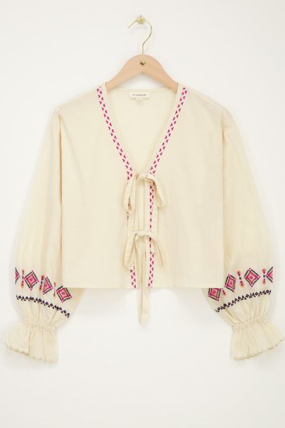 Beigefarbenes Oberteil mit Schleifen und Stickdetails