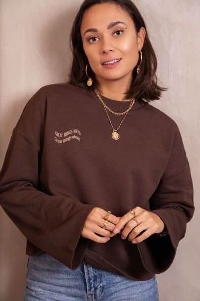 Brown sweater with wave text