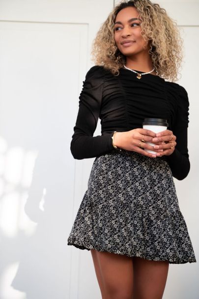 Black ruffled skirt with beige flowers