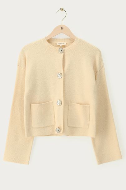 Beigefarbene Strickjacke mit goldfarbenen Knöpfen