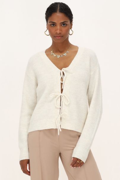 Crème vest met strikjes