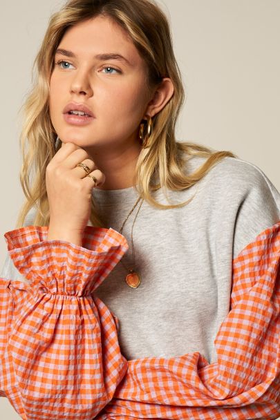 Grey sweater with orange checkered sleeves