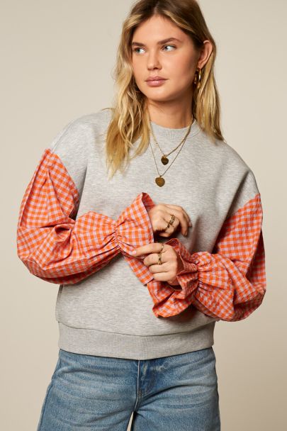 Grey sweater with orange checkered sleeves