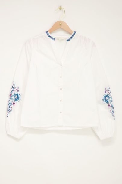 Witte blouse met blauwe embroidery details