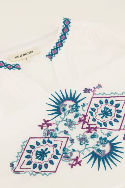 Witte blouse met blauwe embroidery details