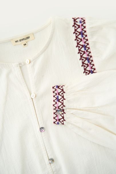 Witte blouse met paarse embroidery