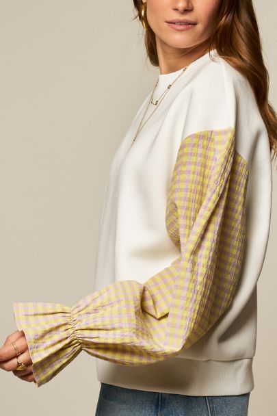 White sweater with yellow checkered sleeves