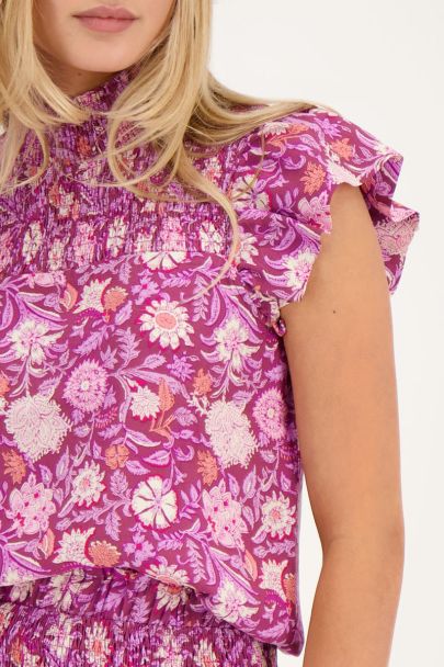 Purple top with pink floral print and smock