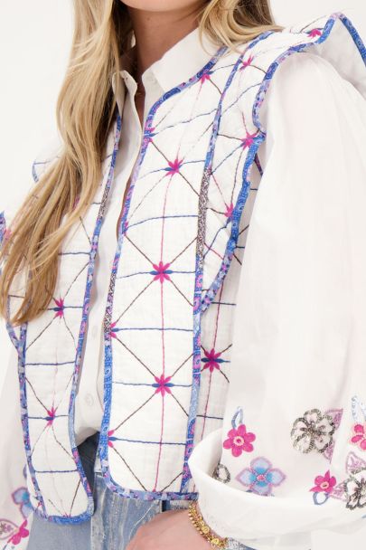 White gilet with blue and pink embroidery