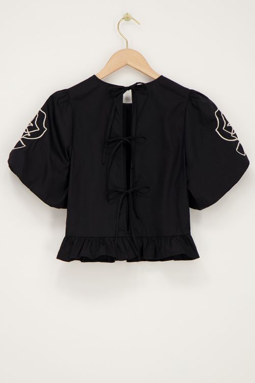 Black blouse with floral detail and bows at back 