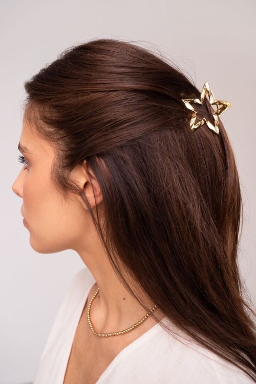 Goudkleurige ster haarclip gedraaid