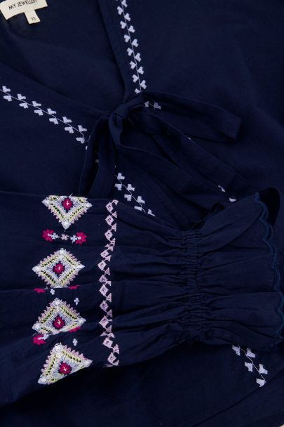 Blaues Oberteil mit Schleifen und Stickdetails