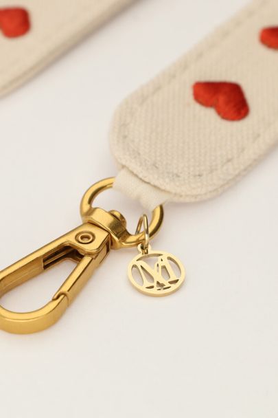 Beigefarbene Handykette mit roten Herzen