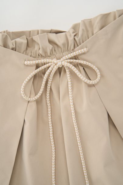 Jupe courte beige plissée avec cordon de serrage