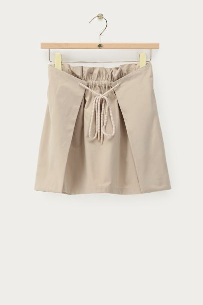 Jupe courte beige plissée avec cordon de serrage