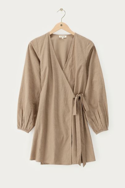 Beige wikkeljurk met embroidery details