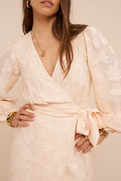 Beige wikkeljurk met lange mouwen en bloemenprint