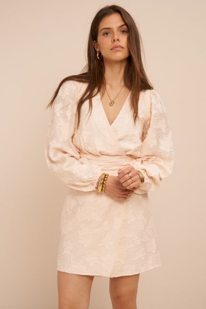 Beige wikkeljurk met lange mouwen en bloemenprint