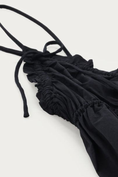 Schwarzes Top mit Spaghetti-Trägern und Schleifen