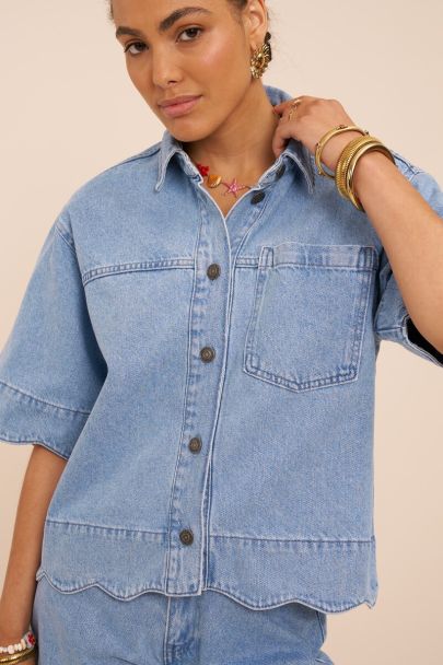 Blauwe denim top met geschulpte rand