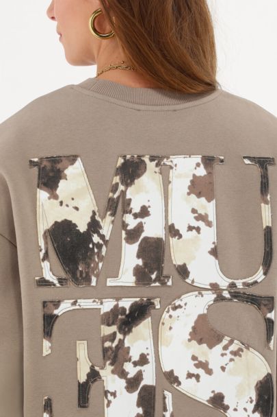 Brown sweatshirt with cow print “Muse” patch
