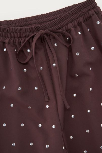 Dark brown trousers with silver-coloured studs