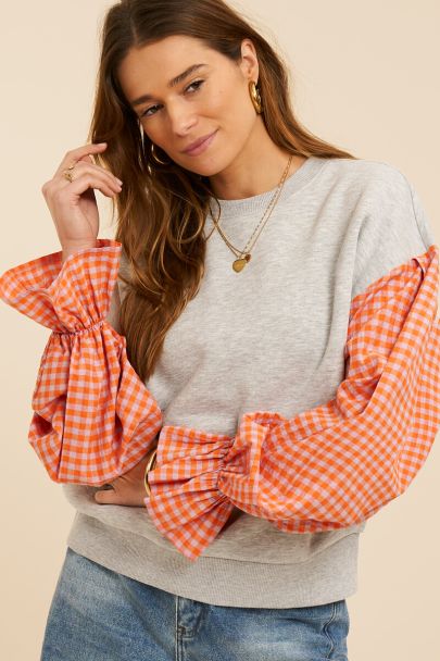 Grey sweater with orange checkered sleeves