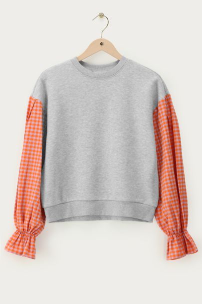Grey sweater with orange checkered sleeves