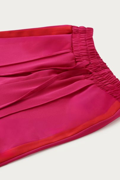 Roze wijde broek in satijn look met rode tape