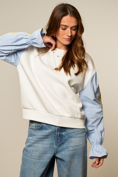 White sweater with blue contrast sleeves