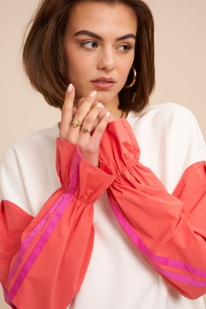 White sweater with coral contrast sleeves