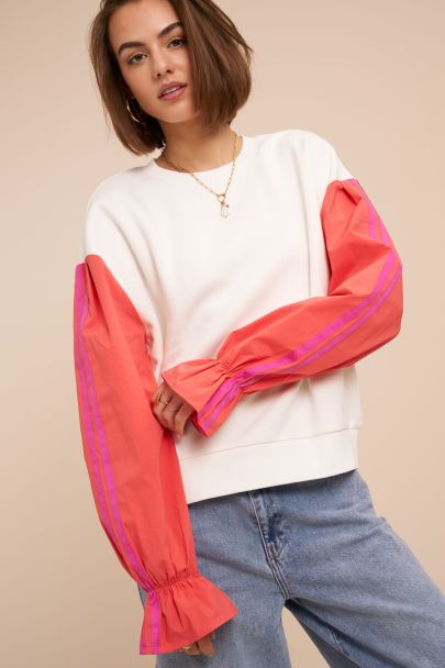 White sweater with coral contrast sleeves