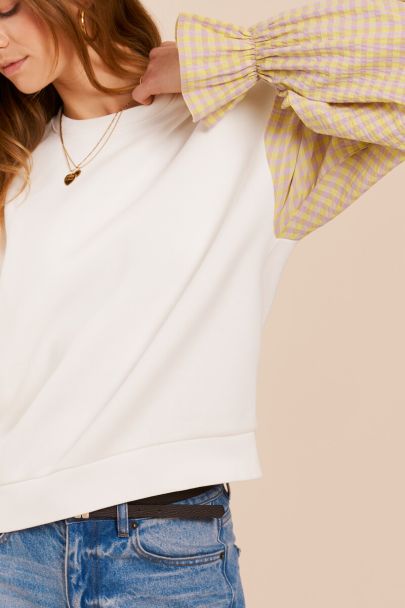 White sweater with yellow checkered sleeves