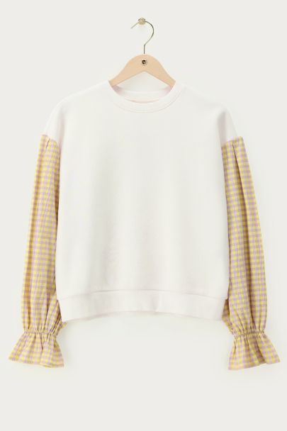 White sweater with yellow checkered sleeves
