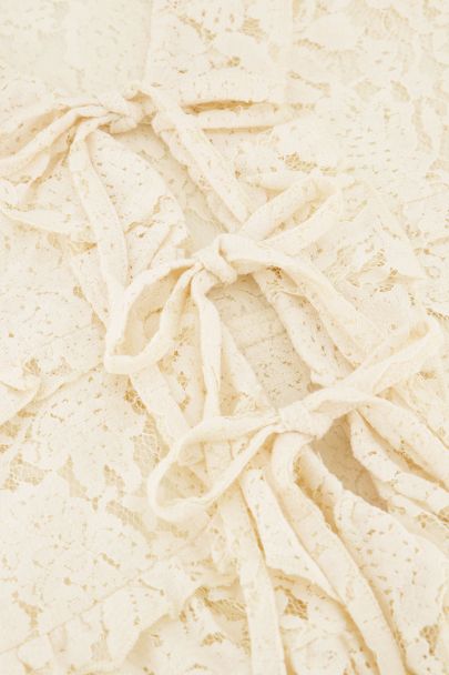 Witte kanten top met ruffles en strikjes
