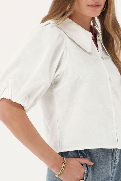 Top blanc avec manches bouffantes et détails de roses