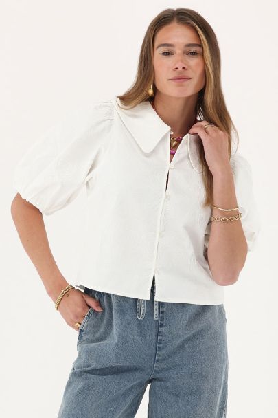 Top blanc avec manches bouffantes et détails de roses