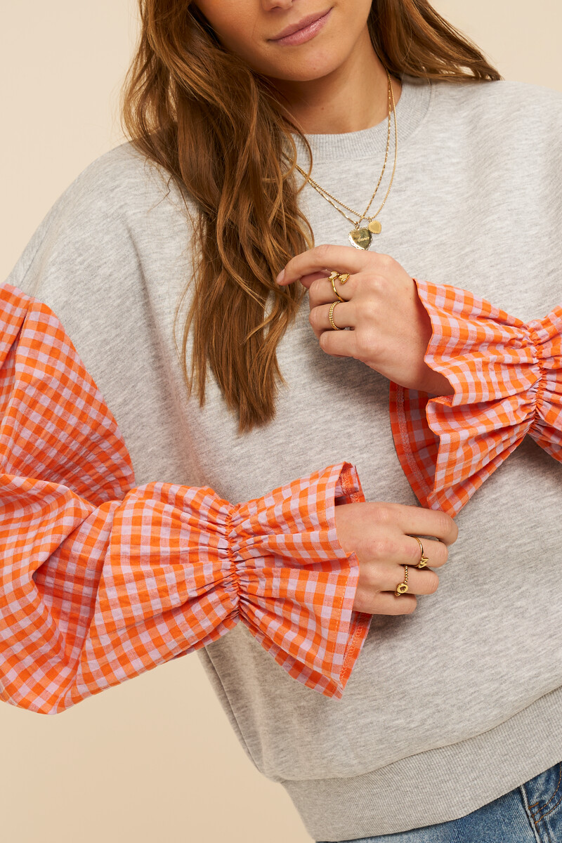 Grey sweater with orange checkered sleeves