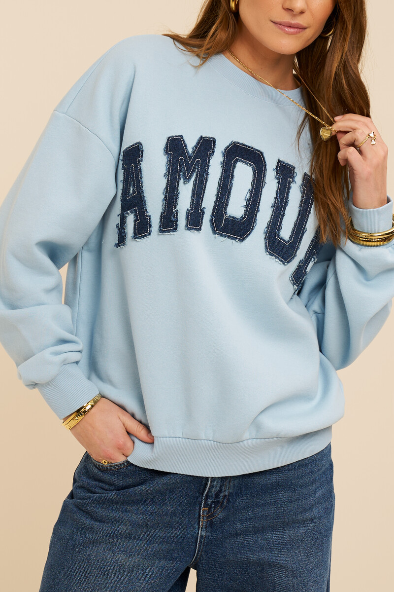 Lichtblauwe sweater met denim patch "Amour"